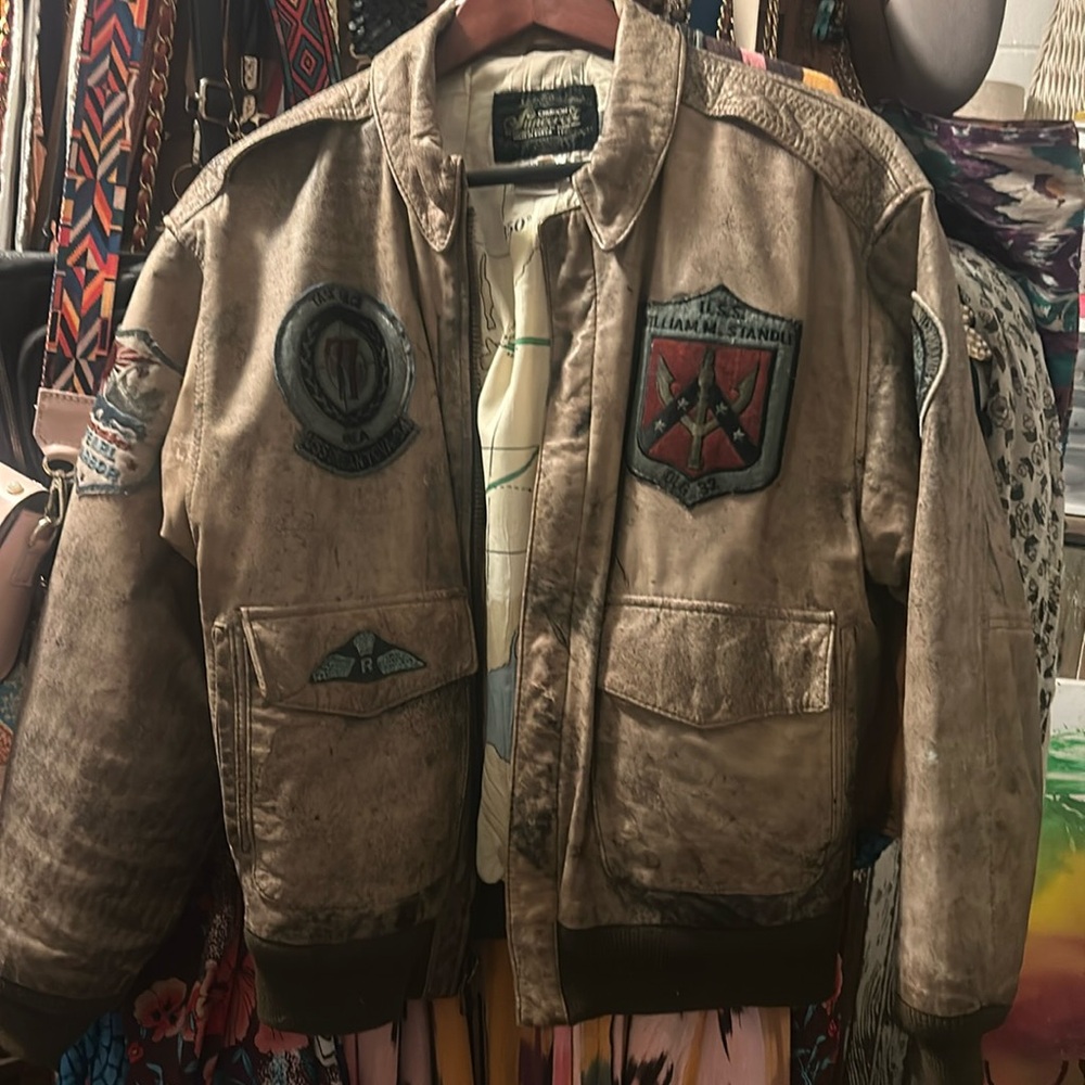 Genuine leather bomber jacket with patches and screen print on back.